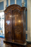 Musée des Arts Décoratifs. Deuxième antichambre.<br> La grande armoire Régence, de la 1ère moitié du XVIIIème siècle, réalisée en acajou moucheté, à haut couronnement, présente une façade plane divisée en trois panneaux symétriques. Au sommet du cintre, un motif naturaliste de corbeille d’osier garnie de fruits .
