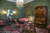 Musée des Arts Décoratifs. Salon vert.<br> Les boiseries de l'hôtel de Gascq remontées ici sont un bel exemple du style rocaille, rare à Bordeaux dans les décors intérieurs privés, qui sont plus généralement de style Louis XVI. A cette particularité s'ajoute celle de leur couleur, un vert très franc rehaussé d'or au-dessus des portes, couleur d'origine retrouvée sous différents repeints et badigeons. La pièce est éclairée, au centre, par un lustre et des appliques murales en bronze doré d’époque Louis XV. Au prmierpla, une table à jeu et à écrire laquée de noir et garnie de bronzes dorés rocaille date des années 1740. Petit meuble à transformation, le plateau amovible permet d’écrire sur la face garnie de maroquin brun, l’autre face est marquetée d’un échiquier. Dans la profondeur de la table est logé un jeu de tric-trac marqueté. Elle est entourée de chaises à décor rocaille foncées de canne, laquées noir et or de la même époque.