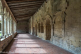 Saint-Emilion. L’ensemble Collégiale.<br> Ce qui sunsiste du cloître roman.. L'aile orientale du cloître a conservé une porte en plein cintre, dont l'archivolte retombe sur uni colonnette d'angle.
Il subsiste de part et d'autre deux baies géminées, dont l'une, a été fortement transformée. Toutes ces arcatures sont soulignées par un cordon sculpté de pointes de diamant, que l'on retrouve également dans les baies des travées orientales de la nef. Il s’agit là des restes de l’entrée de la salle romane du chapitre, dont l’intérieur est aujourd’hui détruit.