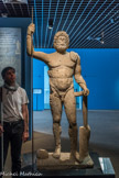 Musée d'Aquitaine. <br> Statue de Jupiter
Fouilles archéologiques à Mézin (Lot-et-Garonne)
3e quart du 1er siècle apr. J,-C.
Calcaire oolithique
Jupiter, dieu romain assimilé à Zeus, apparaît comme le pouvoir suprême : il préside au conseil des dieux. Il est à l'origine la divinité du ciel qui provoque la pluie, lance foudre et éclairs, et celle qui maintient l’ordre et la Justice dans le monde. C'est donc à ce titre qu'il a pour attributs le sceptre (qu'il tenait ici en main droite) et la foudre allée (en main gauche). Il est le garant de la fidélité aux traités, et les officiels notamment (consuls et empereurs) se placent volontiers sous sa protection. La tête du dieu exprime ici la force de celui qui commande aux orages et la grandeur sereine de celui qui fait régner la justice sur la terre comme au ciel. Sa chevelure épaisse et abondante ceinte d’une bandelette s'échappe en boucles ondoyantes autour de son visage. Sa barbe opulente ajoute à la vigueur d'un menton volontaire. La stature en chiasme du dieu (déhanchement provoqué par l'appui sur une jambe),' et l'apparence qui lui est conférée d’un homme dans la force de L'âge imposent le respect.
Que je crains.