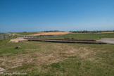 Le Fâ Barzan. <br> La ville portuaire antique du Fâ, en activité du début de notre ère au IIIe siècle ap. J.-C., dort aujourd'hui sous des champs de céréales et de vignes dans un paysage de collines douces baignées par la Gironde. A l'exception du podium du temple circulaire, les traces de cette occupation sont presque invisibles, sauf pour un œil averti qui reconnaîtra la forme semi-circulaire si caractéristique d'un théâtre dans la colline de la Garde au sud-est.
Cette cité fut découverte grâce aux photographies aériennes de l'archéologue prospecteur Jacques Dassié durant les exceptionnelles sécheresses des étés 1975 et 1976. Il a été le premier à déceler le plan de la ville dans les céréales. Vingt ans plus tard, sous l'impulsion de l'ASSA-Barzan, la recherche s'est mise en place. Aujourd'hui, trois équipes scientifiques contribuent à la connaissance du site et, grâce à l'exploration archéologique, décryptent les premiers éléments de son histoire.
Du 1er siècle jusqu'au début du IIIe siècle ap. J.-C., le contexte économique favorable de la Paix Romaine peut expliquer le développement de la ville. En outre, la proximité de MEDIOLANUM SANTONUM (Saintes), civitas (capitale de province), et de voies ralliant BURDIGALA (Bordeaux), est vraisemblablement à l'origine de l'essor des échanges économiques et de l'embellissement de la ville. Il apparaît aujourd'hui évident que cette cité était admirablement située pour constituer un port ouvert sur l'Atlantique par l'estuaire de la Gironde.