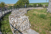 Le Fâ Barzan. <br> Le temple, exhaussé sur un podium, présente un plan circulaire, sur lequel se greffe, à l'est, l'avancée rectangulaire de l'escalier et du porche (surface d'environ 1210 m2). La colonnade frontale à 6 colonnes corinthiennes de ce porche se prolongeait, sur tout le périmètre du podium, par un péristyle qui entoure la cella, et dont la porte fait face à l'escalier. Cette cella domine largement le toit du péristyle. Le fond de son espace intérieur est creusé d'une niche où était installée la ou les statue(s) divine/s). Son mur, parementé en petits moellons rectangulaires disposés en assises régulières, est renforcé à l'extérieur par quatorze pilastres en grand appareil profondément engagés dans la maçonnerie et qui montaient jusqu'à une toiture en coupole, couverte par un toit conique.
A l'intérieur, ce mur était, comme le sol, recouvert de plaques de marbres pyrénéens polychromes. Il était peut-être percé de fenêtres circulaires au-dessus du niveau de la toiture du péristyle. C'est à l'intérieur de cette salle que les prêtres accomplissaient les cérémonies cultuelles, dans lesquelles les quatre fosses creusées dans le sol jouaient certainement un rôle (offrande de libations et d'animaux sacrifiés ?). Les fidèles déposaient leurs dons (statues, objets divers, voire de simples tessons inscrits au nom du dieu ou des monnaies) dans le péristyle et dans les portiques qui entouraient la cour rectangulaire. Cette cour recevait les processions et les banquets cultuels. L'ensemble a vraisemblablement été construit aux frais d'un notable de Saintes, voire à ceux de la communauté (civitas) des Santons, en l'honneur de Mars, successeur d'une divinité celtique locale, peut-être accompagné par une divinité féminine et symbolisant à la fois la cité et la fécondité.