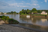 Libourne. <br> Dominé par la tour du grand port, le confluent de l'Isle et de la Dordogne (au fond). La ville tient son nom de son fondateur anglo-normand, Roger de Leybourne, provenant du village de Leybourne dans le comté de Kent, qui, sur l'emplacement du village romain de Fozera, en réalisa le tracé en 1270. Au cours des années, son nom fut légèrement déformé. Il se transforma en Libourne.