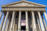 <center><center>Eglise de la Madeleine. </center></center>Un large perron de 28 marches conduit au péristyle; tout autour de l'édifice, une majestueuse colonnade de 52 colonnes cannelées, hautes de 19,50 m, d'ordre corinthien, supporte une frise richement sculptée. Le fronton, par Lemaire, restauré par Jauquié (1904), représente le Jugement dernier.