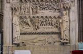 A gauche, Nanthilde, épouse de Dagobert. A droite, Clovis II, fils de Dagobert. De bas en haut : Le gisant de Dagobert couché sur le côté gauche prie en direction du tombeau de saint Denis qui était juste au-dessous de l'autel principal. L'ermite Jean est allongé, endormi. Saint Denis, qui porte la crosse et la mitre des évêques, réveille Jean afin qu'il prie pour l'âme de Dagobert en proie aux démons. C'est le récit que fit l'évêque Ansoald après sa visite à Lipari. L'âme de Dagobert (un enfant nu et couronné) est emportée dans une barque par des démons vers l'île de Stromboli, l'une des îles Éoliennes au Nord de la Sicile. Elles étaient considérées au Moyen Age comme les portes de l'enfer du fait des fréquentes éruptions volcaniques. Les saints Denis, Maurice et Martin arrachent l'âme de Dagobert aux mains des démons. Saint Maurice est un militaire Romain, mort en martyr, car il refusa de massacrer des chrétiens. Sur le tombeau actuel, il tape sur les démons avec une massue.