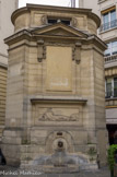 <center></center><center>Fontaine des Haudriettes</center> La fontaine a été construite en 1764 par l'architecte Pierre-Louis Moreau-Desproux sur ordre du prévôt des marchands et aux frais du prince François de Rohan en remplacement de la fontaine Neuve qui datait de 1636. À l'origine la fontaine était adossée à un bâtiment. Elle a plusieurs fois été restaurée, en particulier en 1836 par David et déplacée en 1933 par l'ingénieur L.-C. Heckly pour élargir la rue. Originellement alimentée par les eaux de Belleville, la fontaine a ensuite distribué l'eau du canal Saint-Martin après qu'il a été creusé. Sur le grand côté est le bassin qui recueille l'eau qui jaillit par un mascaron en forme de tête de lion. Au-dessus est un bas-relief de Pierre-Philippe Mignot (1715-1770) qui représente une naïade vue de dos allongée dans les roseaux et appuyée sur son urne, située en applique dans le piédestal du dais. Ce dernier est couronné par un fronton triangulaire et le tout est surmonté d'un attique.