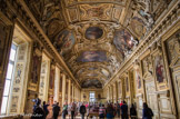 <center>La galerie d'Apollon.</center> Galerie royale, décorée par les plus grands artistes français, la galerie d'Apollon a été conçue à la gloire du roi Louis XIV par l'architecte Louis Le Vau et le peintre Charles Le Brun, à partir de 1661 : le décor de la voûte, composé de 41 peintures et de 36 figures sculptées en stuc, évoque une vision parfaite de l'univers illustrée par le mythe du dieu solaire, Apollon, identifié au jeune roi Louis XIV. L'ensemble laissé inachevé ne sera cependant complété qu'aux XVIIIe et XIXe siècles, notamment avec la commande au peintre Eugène Delacroix de la composition centrale, Apollon vainqueur du serpent Python, et le tissage à la manufacture des Gobelins des 28 portraits d'artistes et de souverains qui ornent le haut des cimaises dorées.