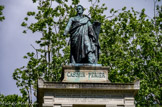 <center>Le cimetière du Père Lachaise </center> Une imposante statue en pied se dresse sur le support. Vêtu d’une toge de magistrat que recouvre une redingote à col officié galonné, Casimir Périer, le bras tendu, semble s’avancer vers quelque action inspirée par sa Loi, la Charte de 1830, gravée sur une table de pierre que tient l’autre main.