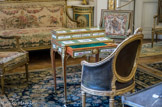<center>Musée Nissim de Camondo</center>Le grand salon. Table à gradin dite « bonheur du jour ». Estampille de Martin Carlin. Vers 1766. Chêne plaqué de bois de rose, ornée de bronzes ciselés et dorés et de plaques de porcelaine tendre de Sèvres. La ceinture, le plateau et le gradin de ce meuble sont ornés de dix-sept plaques de porcelaine à bouquets de fleurs sur fond blanc dans des encadrements verts et or enchâssés dans des montures de bronze. Certaines sont signées des peintres de fleurs Xhrouet, Catrice et Pierre jeune. Le tiroir plaqué de bois de rose forme écritoire. C’est le marchand mercier Simon-Philippe Poirier qui fit appel à Carlin pour lui confier la fabrication de ce type de meubles agrémentés de plaques de porcelaine de Sèvres qu’il commandait à la manufacture. Ce meuble provient des collections du comte d’Aubigny et du général baron de Charrette. Poirier avait livré une table semblable à Madame Du Barry et la comtesse d’Artois, belle-sœur du roi Louis XVI, en possédait également une. Fauteuil de bureau. Attribué à Jean-René Nadal l’aîné, 1775. Noyer sculpté et doré. Couverture en maroquin. Dossier cintré à médaillon ovale surmonté d’une couronne de fleurs et d’instruments de musique, pieds torsadés. Ce siège porte la marque au feu du garde-meuble du comte d’Artois, frère du roi Louis XVI. Il fut livré pour son appartement au château de Versailles en 1775. Derrière, meuble d’encoignures. Estampille de Joseph Feurstein. Vers 1770-1775. Chêne à décor peint et verni blanc et bleu-vert ; bronze ciselé et doré ; dessus en marbre blanc. Chaque vantail à fond bleu ciel à l’origine, qui a verdi avec le temps, est décoré d’un médaillon ovale peint en camaïeu. L’un représente Cérés ou l’Eté, l’autre Flore ou le Printemps. Ce décor est caractéristique de l’adaptation de la technique du vernis parisien au goût néoclassique