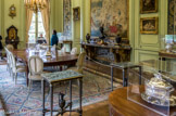 <center>Musée Nissim de Camondo</center>La salle à manger. Autre pièce en angle, en pendant du grand salon, la salle à manger est lambrissée de boiseries peintes en vert dans laquelle sont insérées quatre panneaux de broderies au petit point à décor de vases de fleurs et une tapisserie de Beauvais La Pêche au filet d’après une composition de François-Joseph Casanova. Plusieurs remarquables créations de l’ébéniste Weisweiler sont réunies dans cette pièce : une console desserte d’acajou à fond garni de glaces et une paire de très élégantes petites tables-servantes plaquées d’ébène à entretoise portant une aiguière en bronze. Tapis, manufacture d'Aubusson, point de savonnerie, vers 1760 – 1770, laine. Douze chaises en cabriolet, vers 1775 – 1785, hêtre sculpté peint en gris, couvertes en tapisserie fine d’Aubusson.