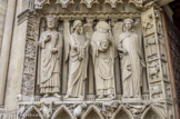 <center>Le portail de la Vierge. </center> A gauche, l’empereur Constantin, un ange, Saint Denis portant sa tête et encore un ange. Les piédroits des deux portes sont consacrés à la vie des hommes. On peut distinguer à gauche et à droite, d’une part les signes du Zodiaque représentant les douze mois de l’année, d’autre part les travaux des mois. Sur le trumeau central figurent à gauche les saisons, à droite les âges de la vie.