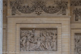 <center>Bas-relief.</center>En 1837, on commande au sculpteur Nanteuil (1792-1865) trois bas-reliefs situés sous le péristyle, pour remplacer ceux de l’époque révolutionnaire. Au-dessus de la porte centrale se trouve « L’Apothéose du héros mort pour la patrie ». L’Histoire est représentée avec une canne se terminant avec un coq qui par un jeu de mots renforce le sens de la nation : gallus en latin, la Gaule. La Patrie console, en lui offrant une palme, un citoyen mourant dont la Renommée proclame les hauts faits.