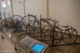<center></center><center>Musée des Arts et Métiers.</center> Vélocipède Michaux à corps ondulé, 1865.
Les véhicules individuels à deux roues ou « vélocipèdes » existent dès 1818, telle la «draisienne », mais c’est l’invention du pédalier par Pierre et Ernest Michaux qui amorce leur diffusion. Avec le vélocipède commence une révolution du transport individuel, qui prépare le succès de l’automobile.
L'invention du pédalier.
L’idée d’un véhicule individuel à deux roues en ligne reliées par une traverse de bois remonte peut-être au XVIIe siècle. L’Allemand Charles de Drais l’équipe en 1818 d’un pivot pour diriger la roue avant. En 1861, le serrurier parisien Pierre Michaux et son fils Ernest ont ensemble l’idée d’adapter des pédales au moyeu de la roue avant d’une «	Draisienne», ce qui permet d’avancer sans donner l’impulsion sur le sol avec les pieds. En outre, les pièces de bois sont remplacées par de la fonte malléable, et le guidon peut actionner une corde reliée à un levier qui s’appuie sur la roue arrière pour freiner.
Le transport individuel sans cheval.
La diffusion du vélocipède puis de la « bicyclette » (roue arrière motrice) permet d’affranchir peu à peu du cheval les transports individuels rapides et longs. Elle prépare ainsi l’avènement de l’automobile.
De nombreux métiers se trouvent transformés par l’usage de la « petite reine », véhiculepopulaire par excellence. La course organisée en 1869 près de Paris lance le sport cycliste.
