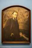 <center>Exposition Toulouse-Lautrec.</center> Octave Denis Victor Guillonnet (1872-1967)
Portrait de Cormon
Vers 1910
Huile sur toile. Peint au temps du cubisme, ce portrait allégorique se retourne vers les années 1880 par l’évocation, à l’arrière-plan, de ce qui fut le succès initial du peintre Cormon : son Caïn avait alors imposé la manière d’un jeune maître, réaliste et lyrique, et ressuscité un monde, celui de la préhistoire et d’une humanité dont l’énergie primitive tranchait sur l’âge moderne. Lautrec, qui entre chez Cormon en 1882, y restera près cinq ans. Il en tira les éléments de son premier style, robuste, poignant et curieux de l’humain jusqu’à l’os.