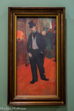 <center>Exposition Toulouse-Lautrec.</center> Le Docteur Tapié de Céleyran
1893-1894
Huile sur toile.
Gabriel Tapié de Céleyran, cousin germain du peintre, s’avance vers nous avec nonchalance dans un couloir de la Comédie-Française. Lautrec semble saisir son attitude à son insu et traduit la personnalité de celui qu’l surnomme avec un humour caustique « Tapir le scélérat ». Par un procédé de balayage courbe du sol, vu en perspective très relevée, il accentue sa présence expressive et sa haute stature, et le visage grimaçant de la dame du vestiaire au-dessus de son épaule n’est pas sans évoquer les masques de l’artiste belge James Ensor.