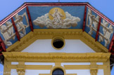 <center>Saint-Nicolas-de-Véroce</center>Le décor de l’auvent, création du peintre Gabriel, trouve sa place entre les pièces de charpente de couleur sang de bœuf comme le portail de la façade. Le décor a été peint sur des toiles marouflées. De chaque côté, des fenêtres ouvrent sur le ciel, dans la pure tradition baroque. Le panneau central oublie la Trinité pour représenter Dieu le père avec la Colombe de l’Esprit Saint dans un ciel ouvrant sur la lumière. On retrouve là le «trompe-l’œil» caractéristique du baroque.