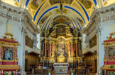 <center>Saint-Nicolas-de-Véroce</center>Le retable de Jacques Clérant (1698) de l’ancienne église est remplacé par celui d’Albertini en 1771. Il sera légèrement retouché au début du XIXème siècle par des adjonctions néo-classiques. Deux piédroits de deux étages de hauteur inégale sont peints de manière à imiter des marbres polychromes. Au-dessus des piédroits sont posés des chapiteaux doriques aux tailloirs proéminents : ce sont les supports d’un arc surbaissé qui ferment l’espace du haut. Ce faux porche est surmonté d’un dais en pourpre majestueux en forme de dôme.