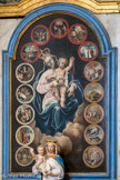 <center>Saint-Nicolas-de-Véroce :  Église  Saint-Nicolas-de-Myre.</center> Les quinze petits médaillons sur le tableau représentent les 15 mystères de la vie de Marie :  5 joyeux (L'Annonciation de l'Ange Gabriel à la vierge Marie  ; La Visitation de la vierge Marie à sa cousine Elisabeth ; La Naissance de  Jésus ; La Présentation de Jésus au Temple de Jérusalem ; Le Recouvrement de Jésus au Temple de Jérusalem) , 5 douloureux (L'Agonie de Jésus au jardin des oliviers ; La Flagellation de Jésus ; Le Couronnement d'épines de Jésus ; Le Portement de la Croix de Jésus ; La Crucifixion de Jésus et la mort de Jésus sur la Croix) et 5 glorieux (La Résurrection de Jésus : L'Ascension de Jésus au Ciel ; La Pentecote : la descente du Saint-Esprit ; L'Assomption de la vierge Marie au Ciel ; Le Couronnement de la vierge Marie au Ciel).