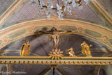 <center>Hauteluce : Église Saint-Jacques-d'Assyrie.</center> Au-dessus de l'avant chœur : un calvaire. Ce calvaire sur poutre de gloire représente le Christ en croix, à sa droite, Marie (avec une épée plantée dans la poitrine), Marie Madeleine et Saint Jean. Le pied de la Croix est orné d'une sorte de gloire circulaire et rayonnante dans laquelle sont disposées 3 têtes d'anges.